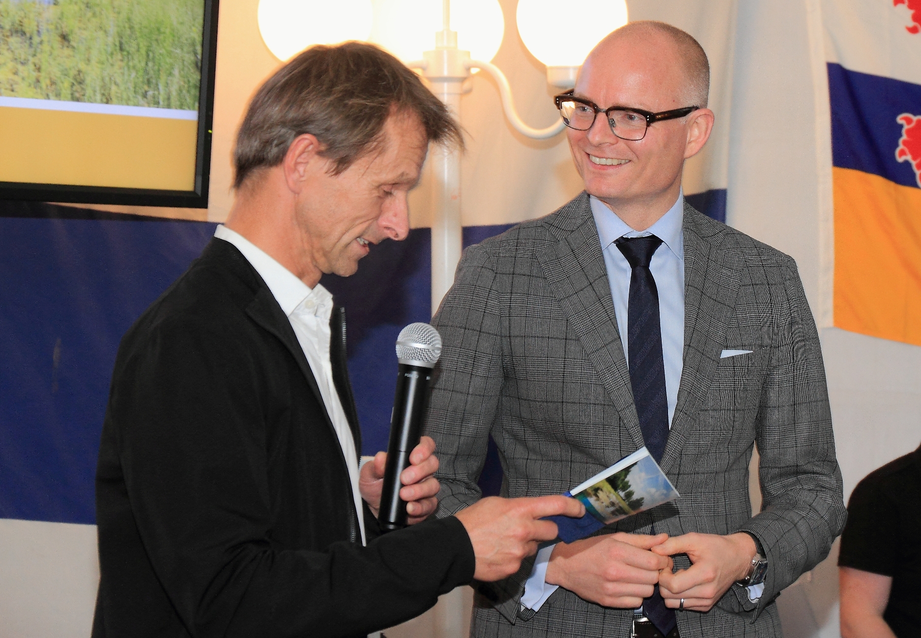 Jos Rademakers (L), directeur ARK Natuurontwikkeling, overhandigt eerste exemplaar van ‘Wild, weerbaar en waterveilig’ aan gedeputeerde Hubert Mackus. – foto: Ruud van Nooijen